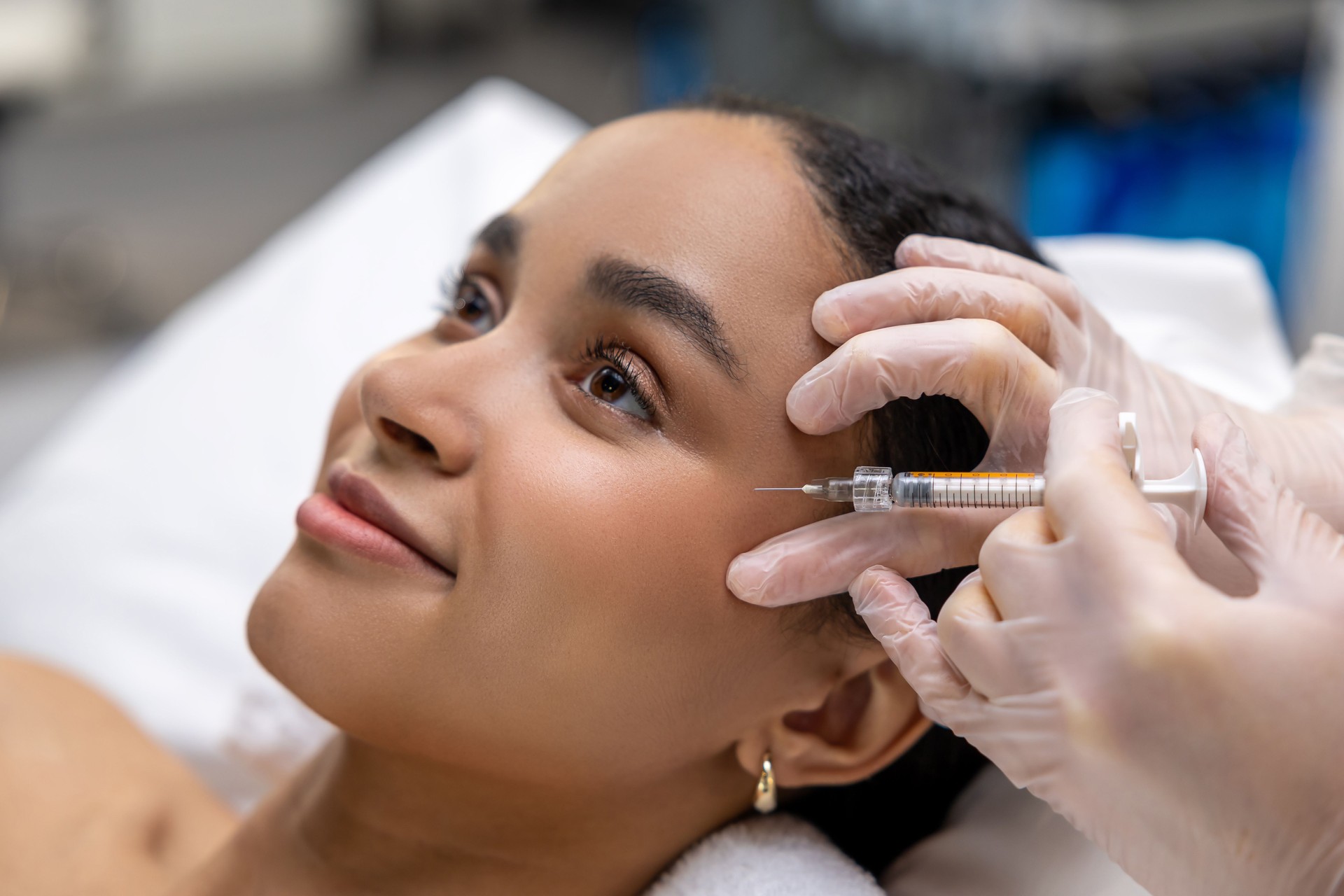 Young dark-skinned woman having a session of mesotherapy